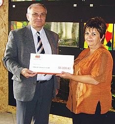 Milan Bartl, vedoucí odboru řízení provozu Elektrárny Ledvice předává jako čestný host nadace ČEZ symbolický šek na 50 000 korun ředitelce DDM Bílina Kristě Sýkorové.